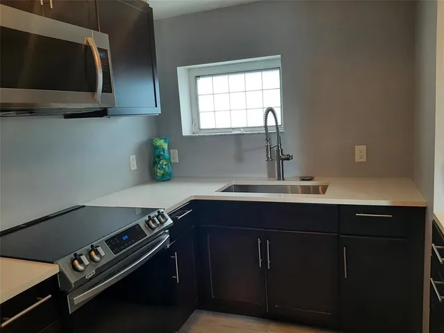 a kitchen with a sink a stove and cabinets