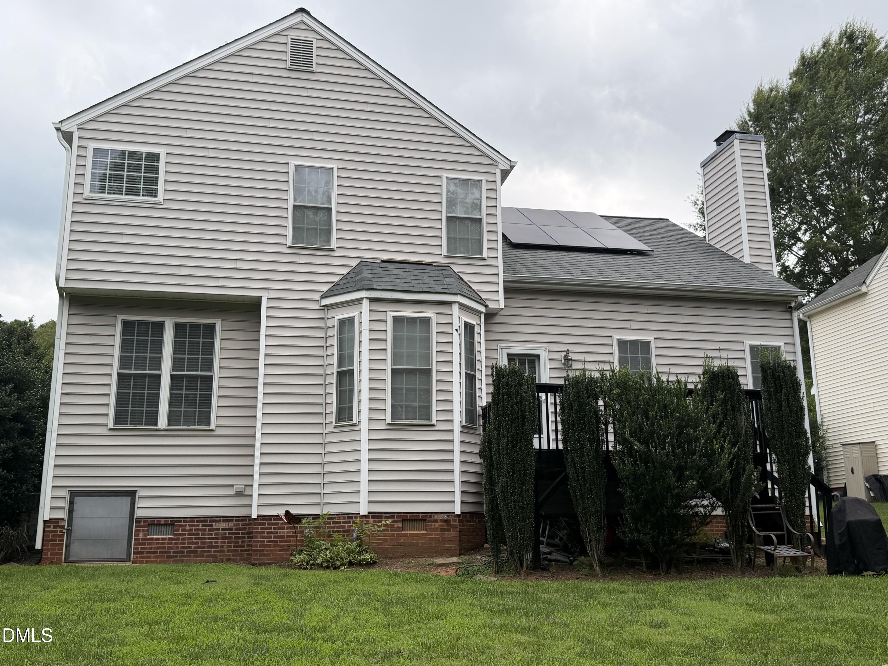 1849 Hanford Hills Road Graham, NC 27253 - Photo 4 of 11 Rear exterior featuring light-colored siding, multiple windows, a bay window, and a deck with stairs
