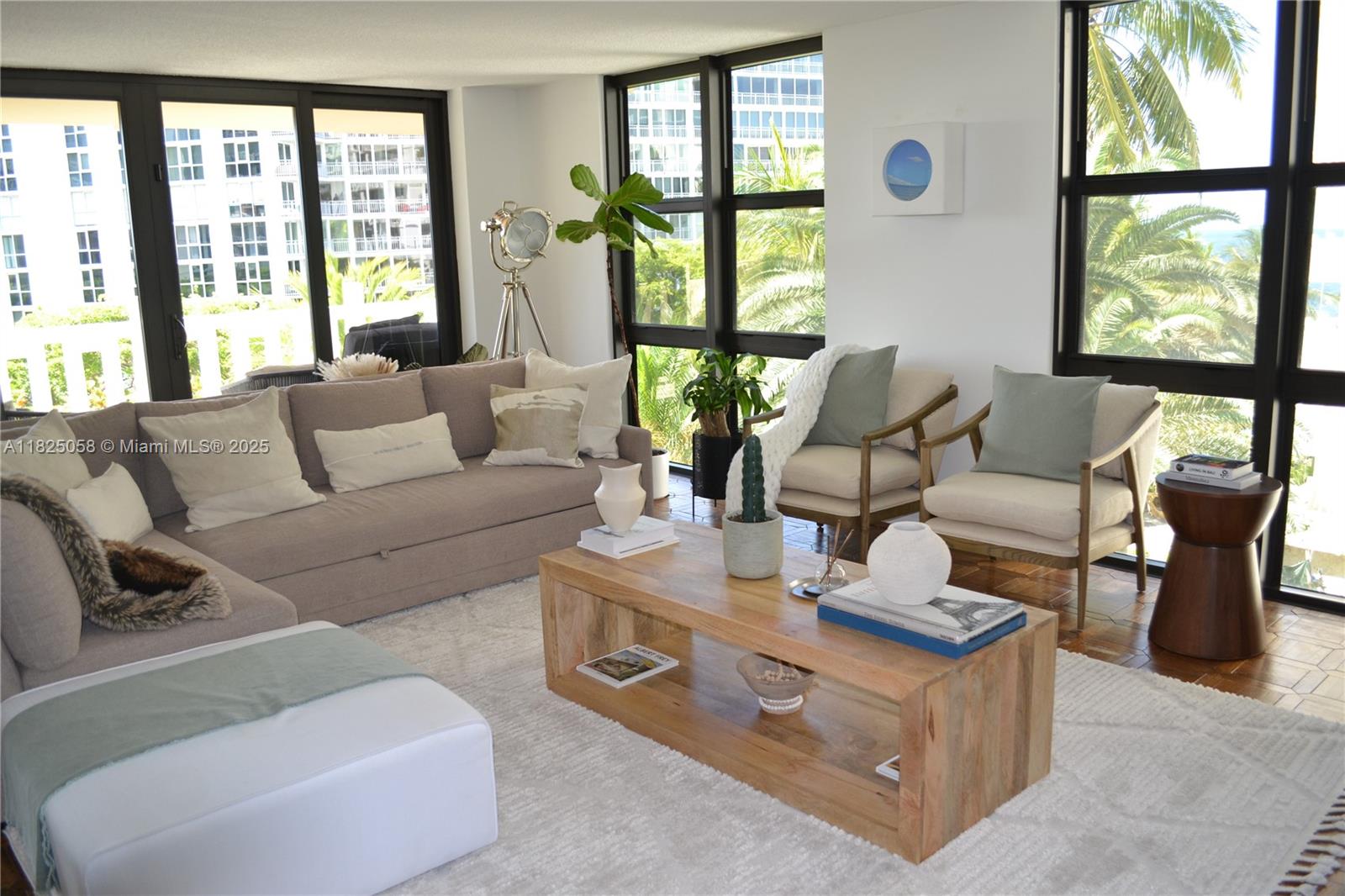 a living room with furniture and floor to ceiling windows