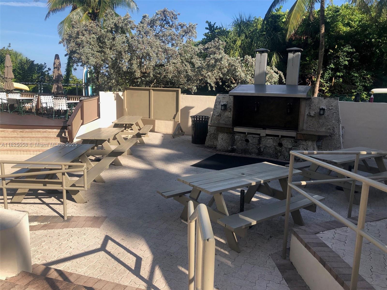 1111 Crandon Boulevard, Unit C402 Key Biscayne, FL 33149 - Photo 27 of 32 a terrace with outdoor seating and trees