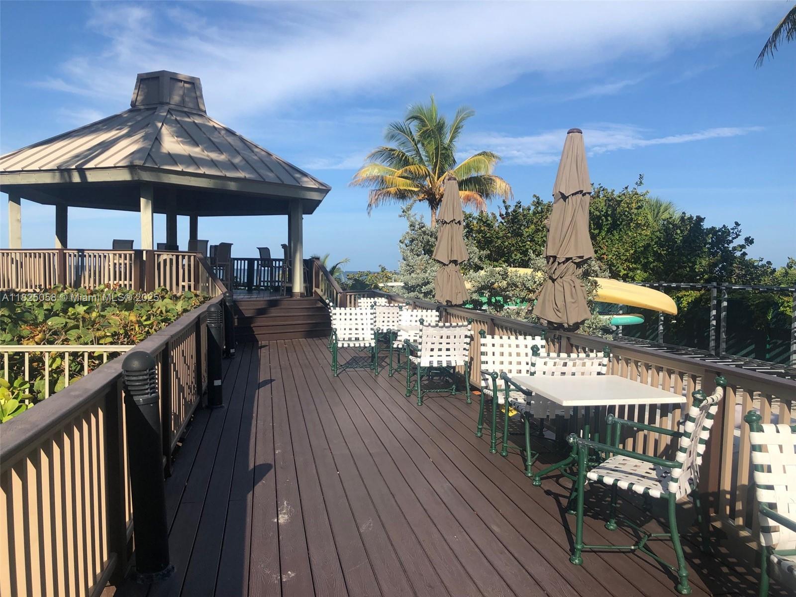 1111 Crandon Boulevard, Unit C402 Key Biscayne, FL 33149 - Photo 28 of 32 a view of a balcony with wooden floor and outdoor seating
