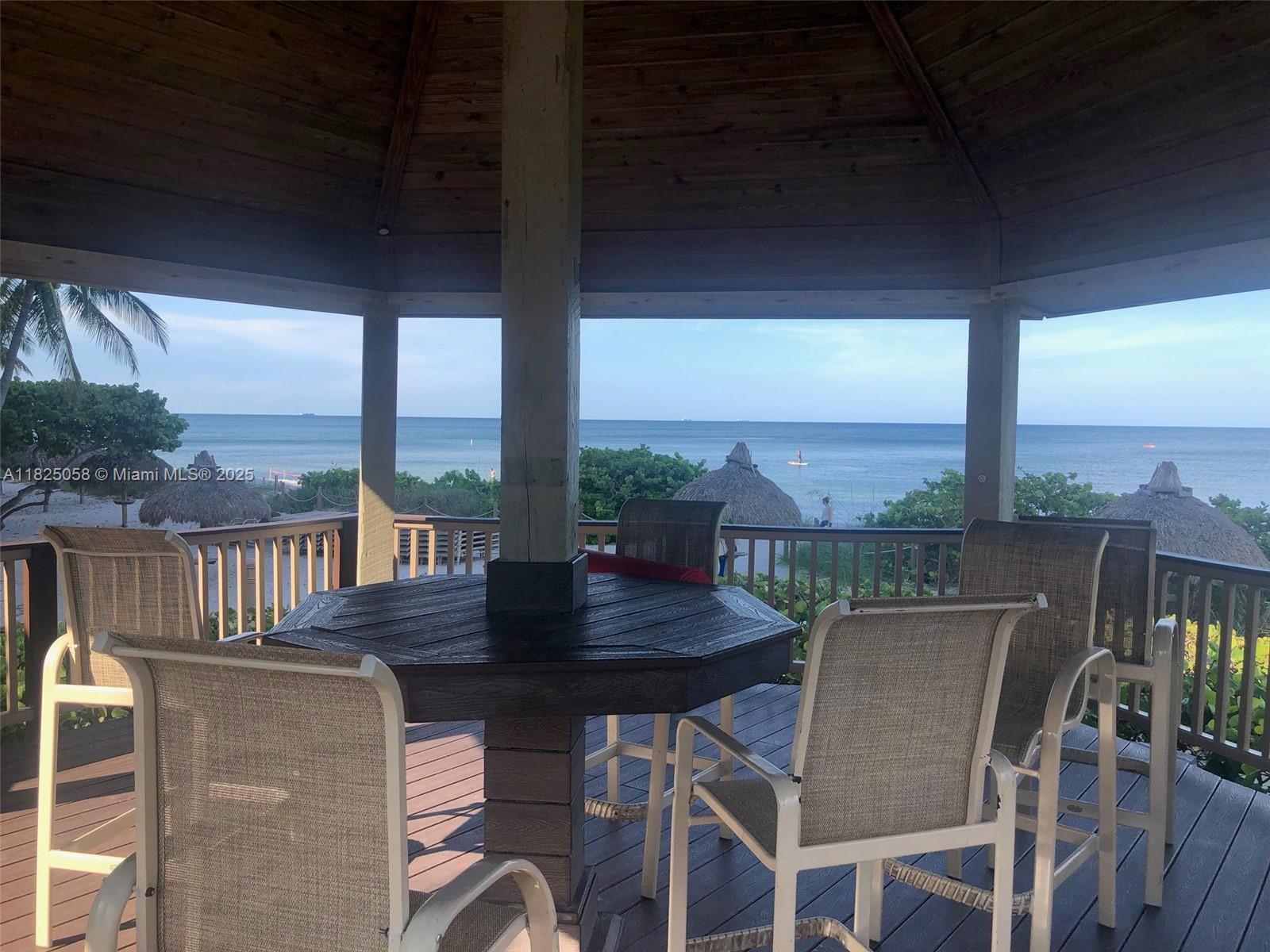 1111 Crandon Boulevard, Unit C402 Key Biscayne, FL 33149 - Photo 30 of 32 a view of a balcony with a table and chairs