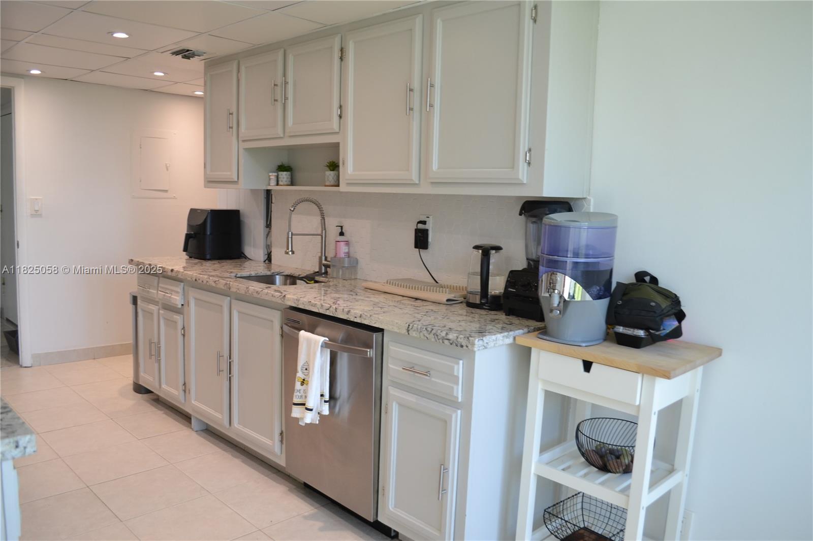 1111 Crandon Boulevard, Unit C402 Key Biscayne, FL 33149 - Photo 8 of 32 a kitchen with stainless steel appliances granite countertop a sink a stove a microwave and cabinets