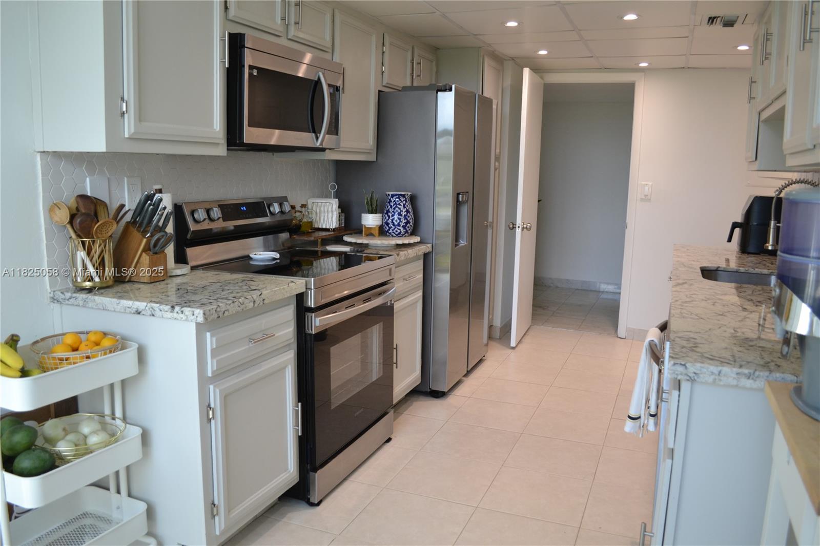 1111 Crandon Boulevard, Unit C402 Key Biscayne, FL 33149 - Photo 9 of 32 a kitchen with stainless steel appliances granite countertop a refrigerator stove and microwave