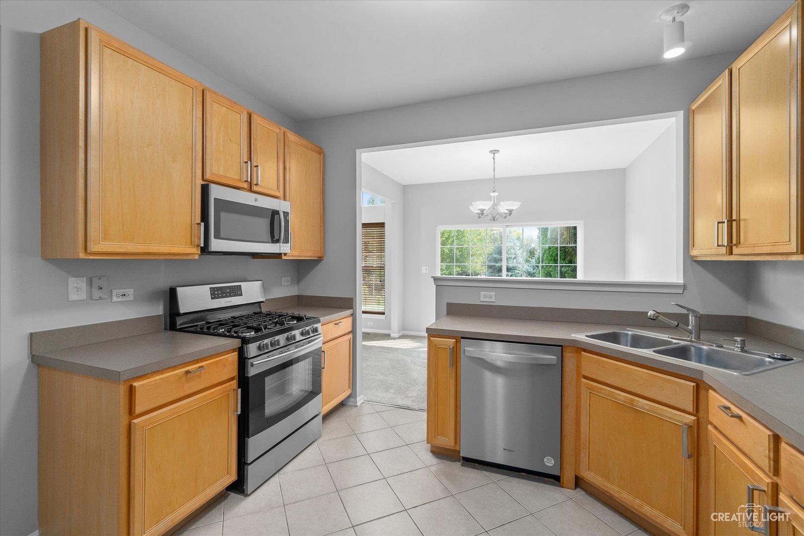 19 Lily Court Bolingbrook, IL 60440 - Photo 10 of 31 a kitchen with stainless steel appliances granite countertop white cabinets a stove a sink and a microwave