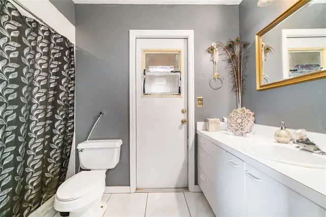 a bathroom with a granite countertop toilet sink and mirror