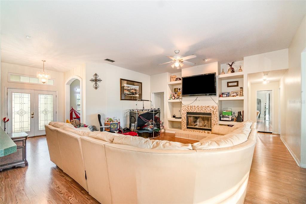 22631 Robbins Road Astatula, FL 34705 - Photo 5 of 35 a living room with fireplace furniture and a flat screen tv