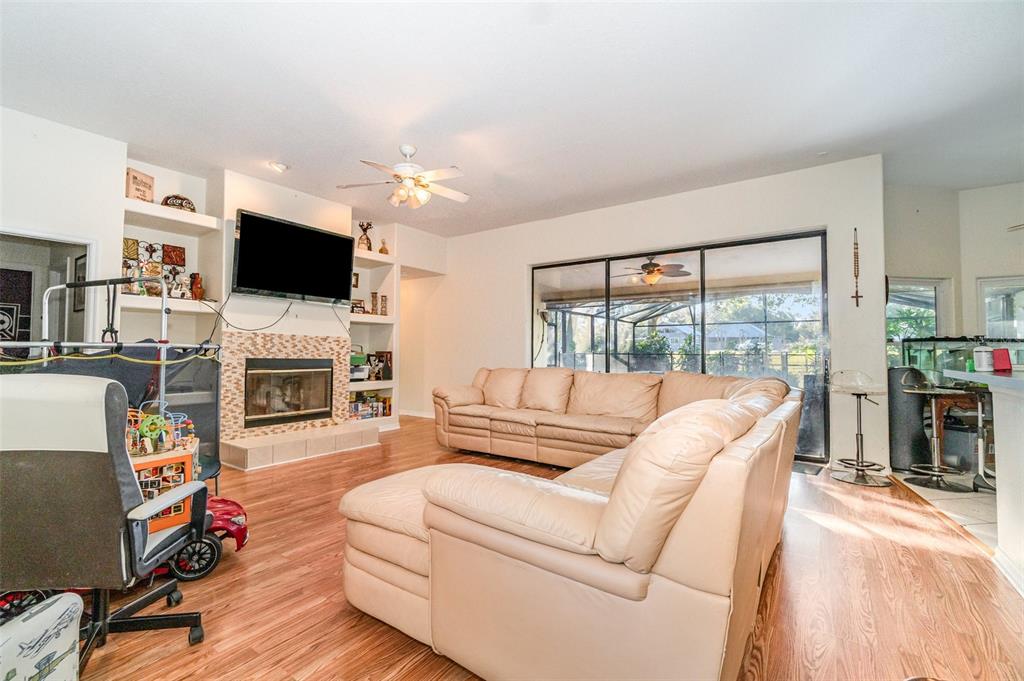 22631 Robbins Road Astatula, FL 34705 - Photo 6 of 35 a living room with furniture a flat screen tv and a fireplace