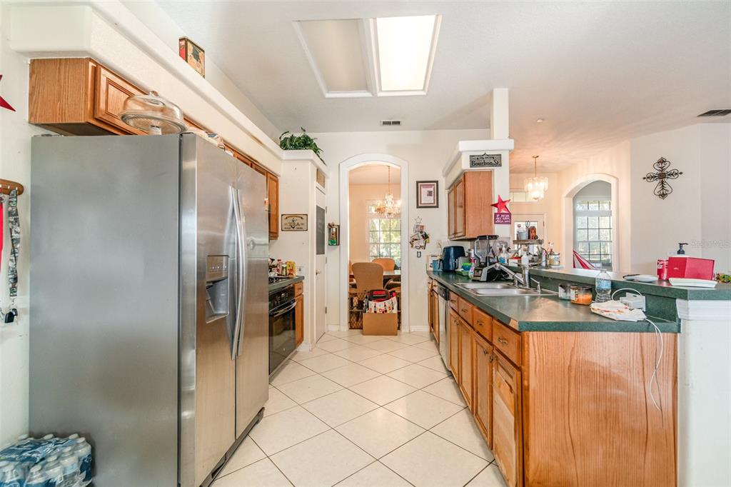 22631 Robbins Road Astatula, FL 34705 - Photo 10 of 35 a kitchen with stainless steel appliances kitchen island granite countertop refrigerator and cabinets
