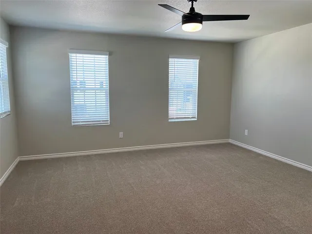 an empty room with a window and a ceiling fan