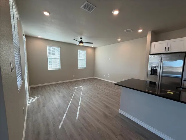 a view of a kitchen with a sink and dishwasher a refrigerator with wooden floor