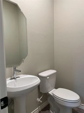 a bathroom with a sink toilet and a mirror