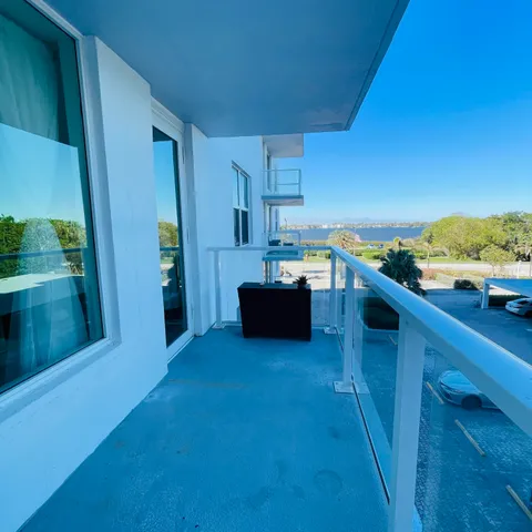 a view of a lake with a yard and large trees