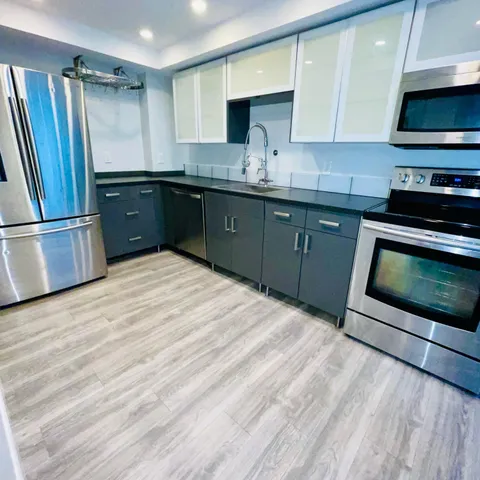 a kitchen with stainless steel appliances granite countertop a sink stove and cabinets