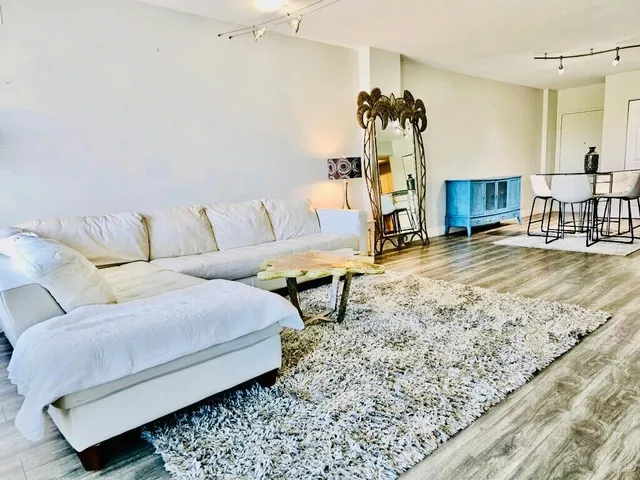 a spacious bedroom with a bed and wooden floor