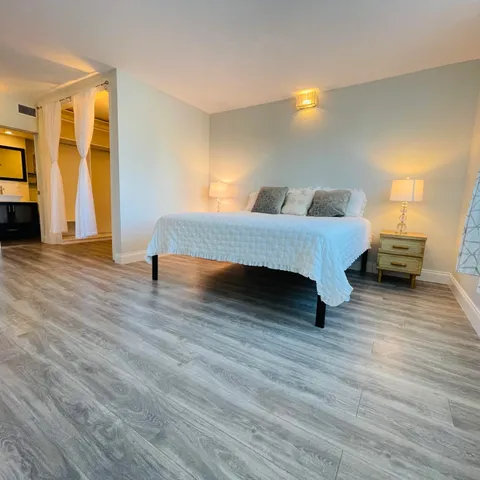 a view of empty room with wooden floor and window