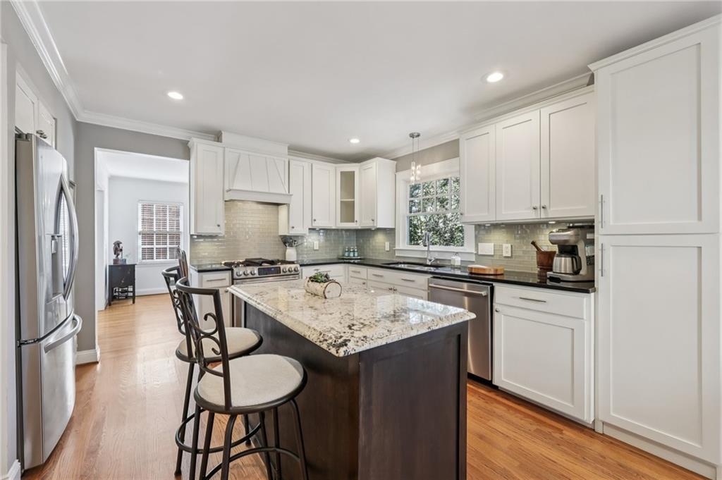 101 Dartmouth Avenue Avondale Estates, GA 30002 - Photo 12 of 53 a kitchen with stainless steel appliances granite countertop a table chairs sink refrigerator and cabinets