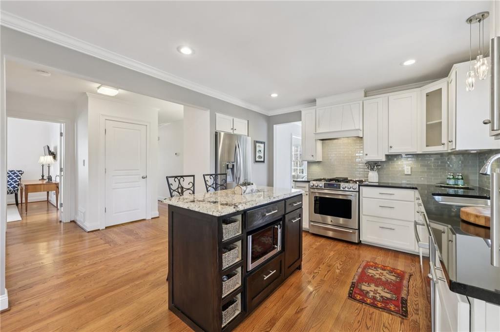 101 Dartmouth Avenue Avondale Estates, GA 30002 - Photo 17 of 53 a kitchen with stainless steel appliances granite countertop a stove top oven a sink dishwasher a refrigerator and white cabinets with wooden floor