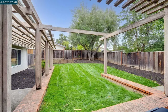 a view of a backyard with wooden fence
