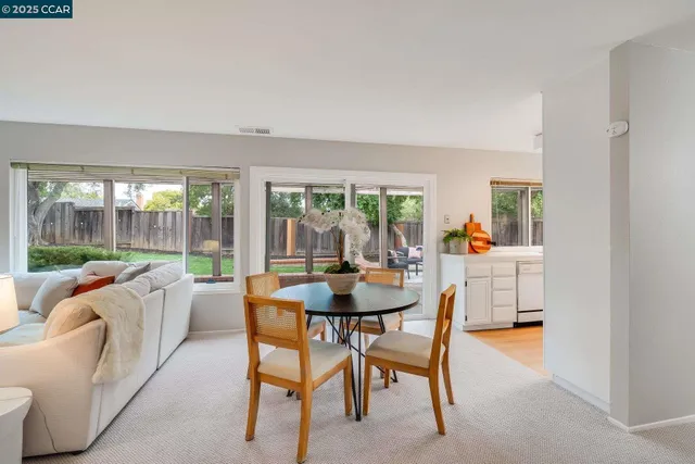 a dining room with furniture and a floor to ceiling window