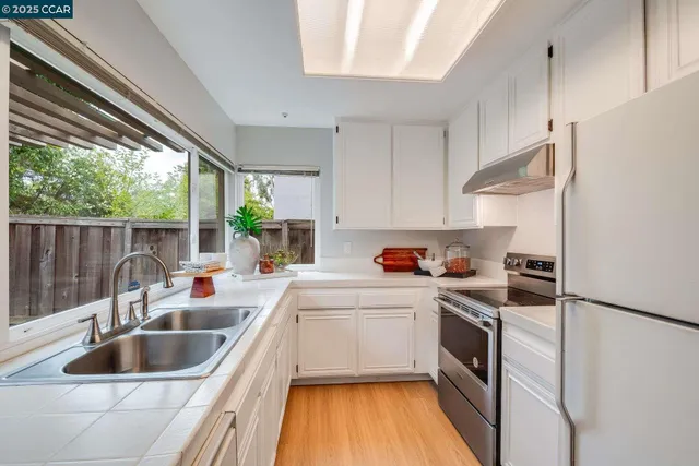 a kitchen that has a sink and a stove top oven