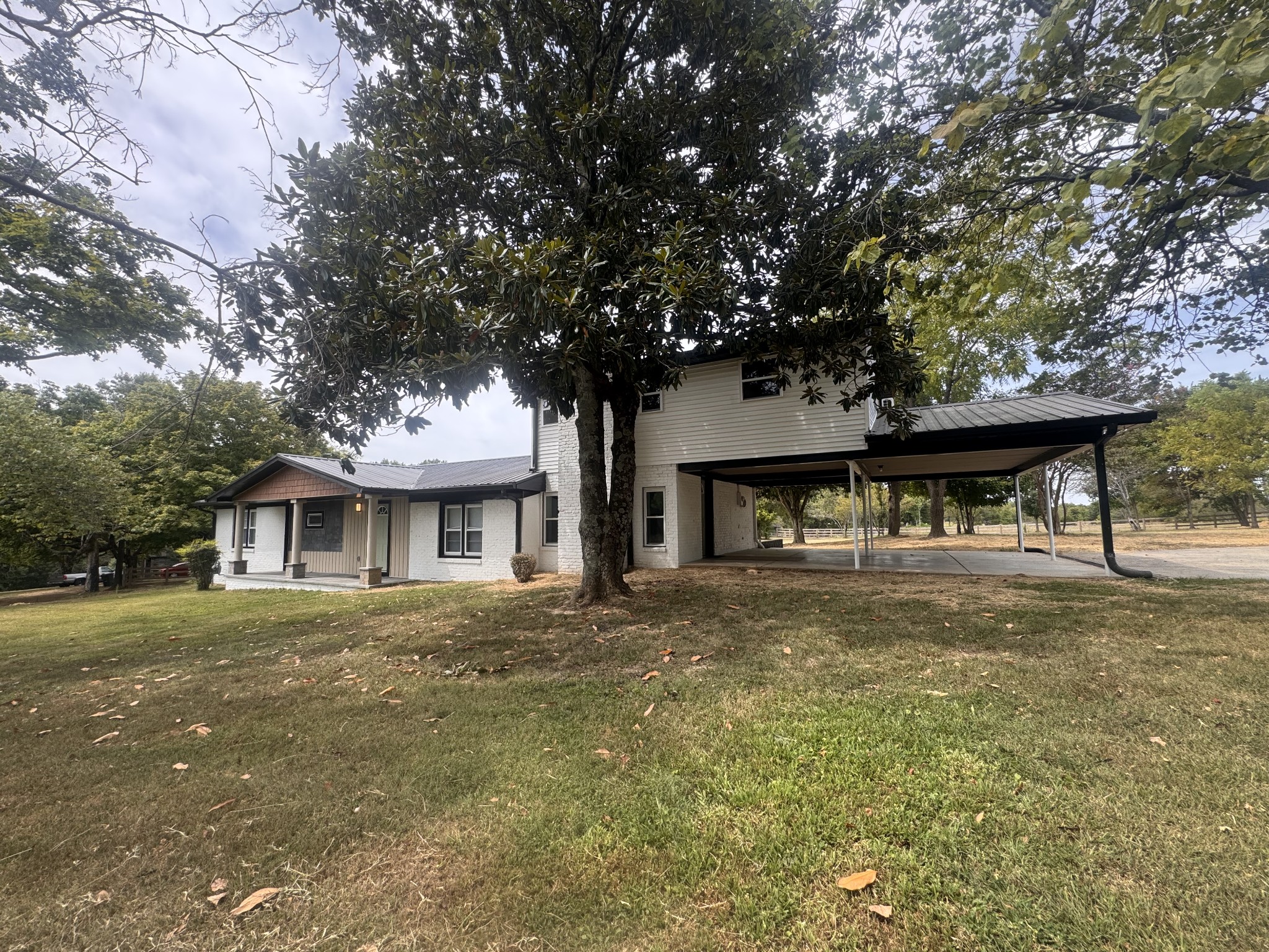 a front view of a house with a garden and trees
