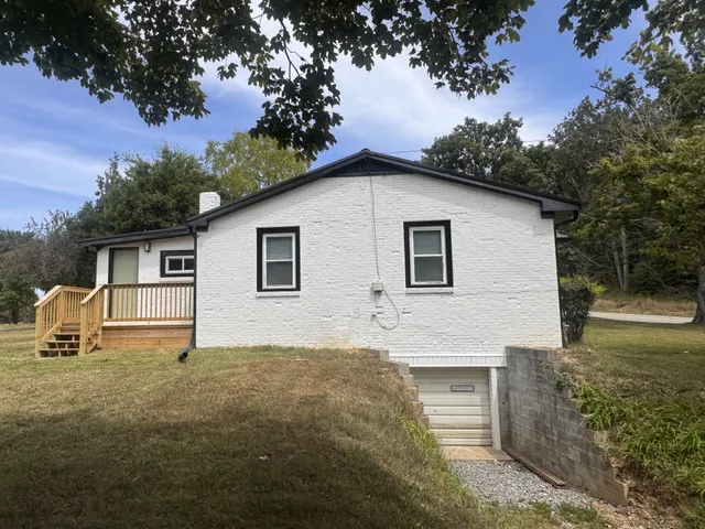 a backyard of a house with potted plants and large tree