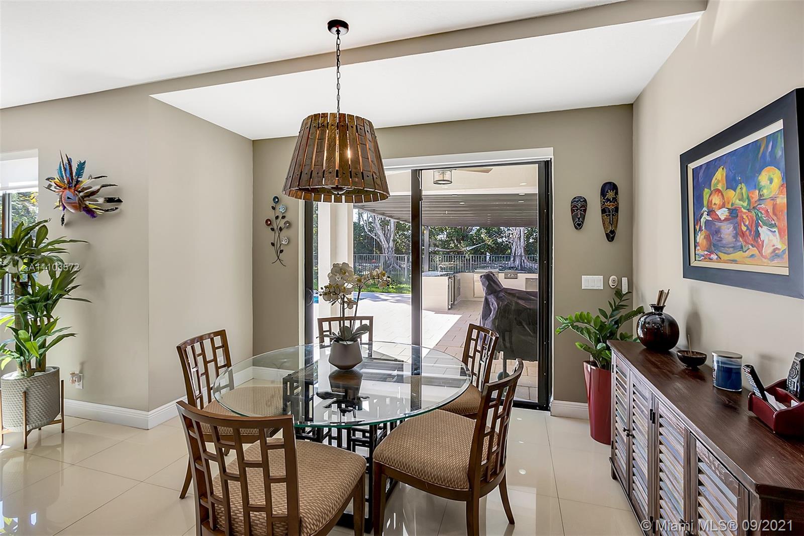 19124 Seneca Avenue Weston, FL 33332 - Photo 11 of 38 a view of a dining room with furniture one side kitchen view and wooden floor