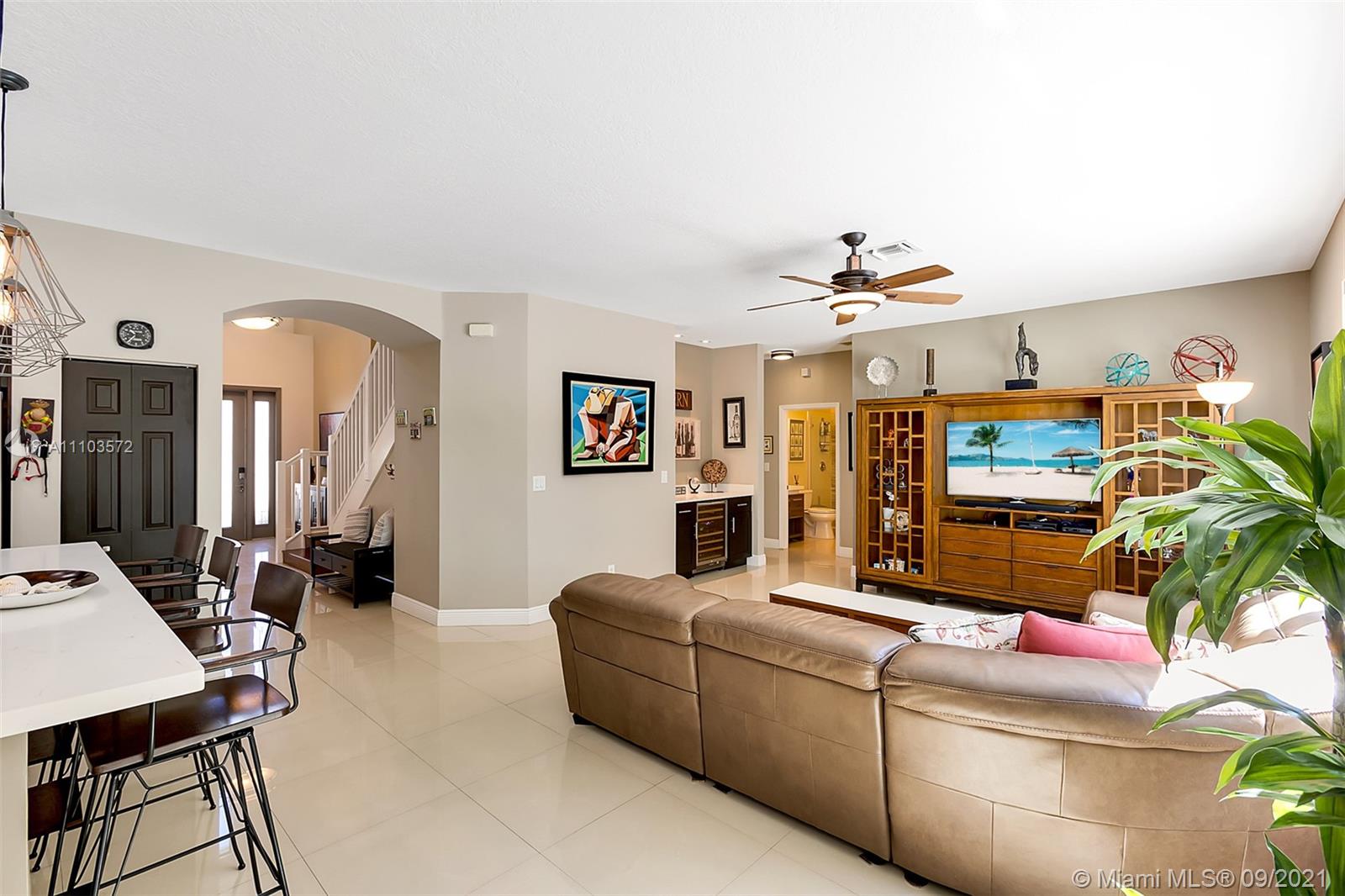 19124 Seneca Avenue Weston, FL 33332 - Photo 12 of 38 a living room with furniture and a chandelier