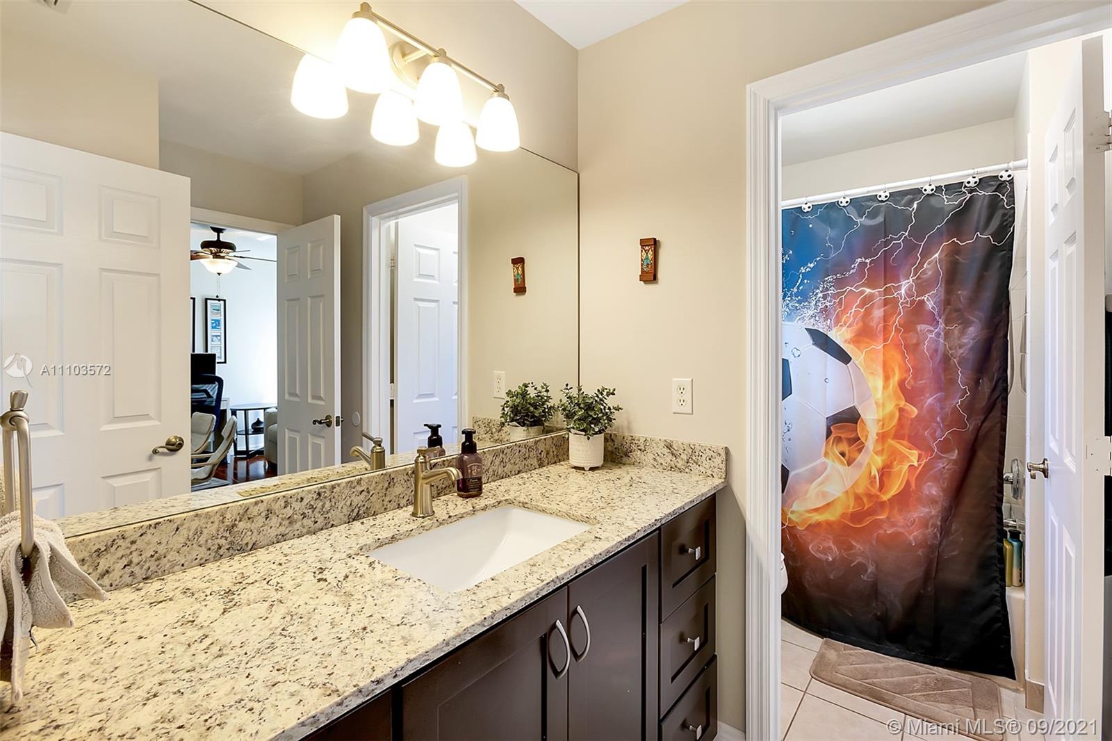 19124 Seneca Avenue Weston, FL 33332 - Photo 26 of 38 a bathroom with a granite countertop sink and a mirror