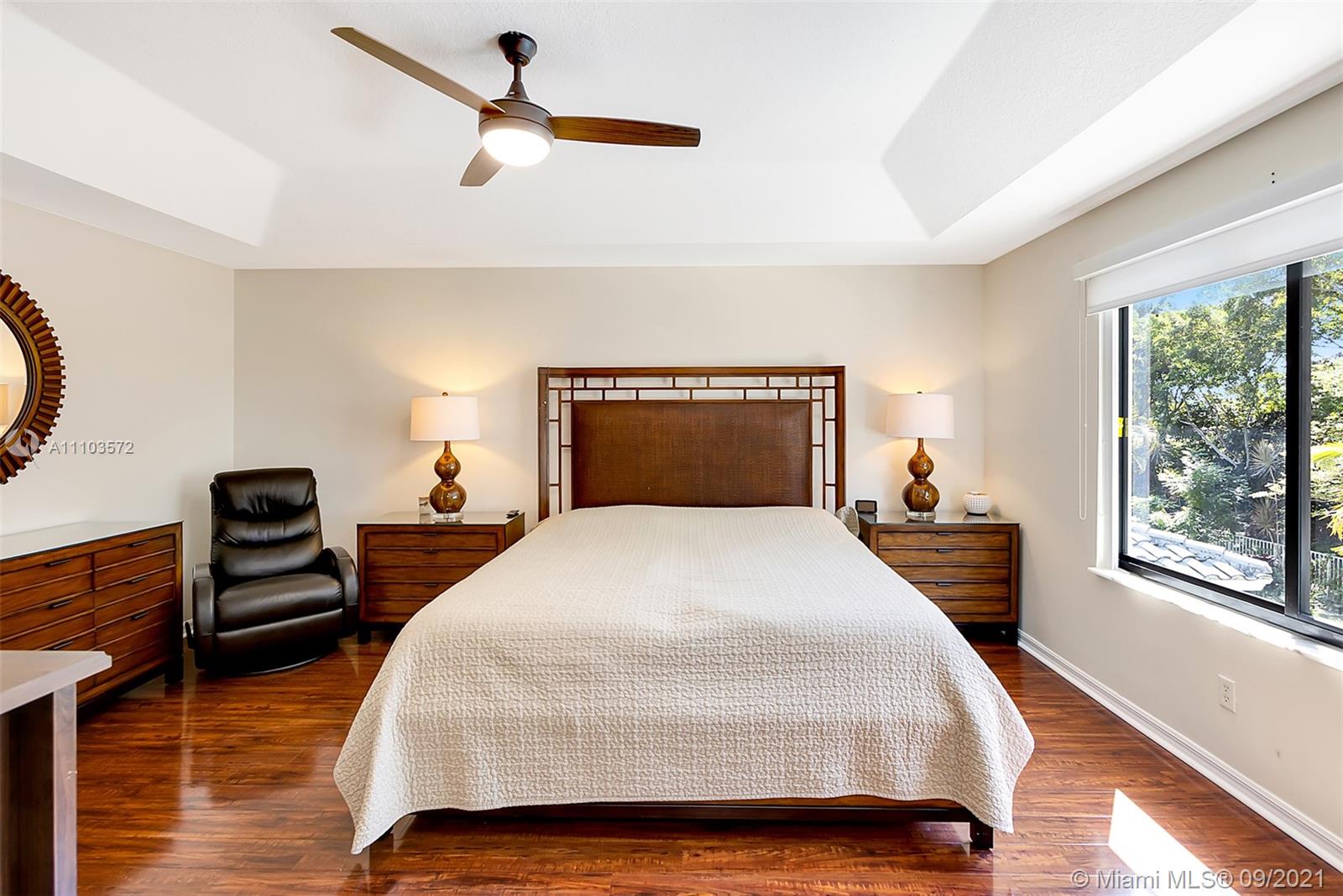 19124 Seneca Avenue Weston, FL 33332 - Photo 29 of 38 a bedroom with a bed and wooden floor