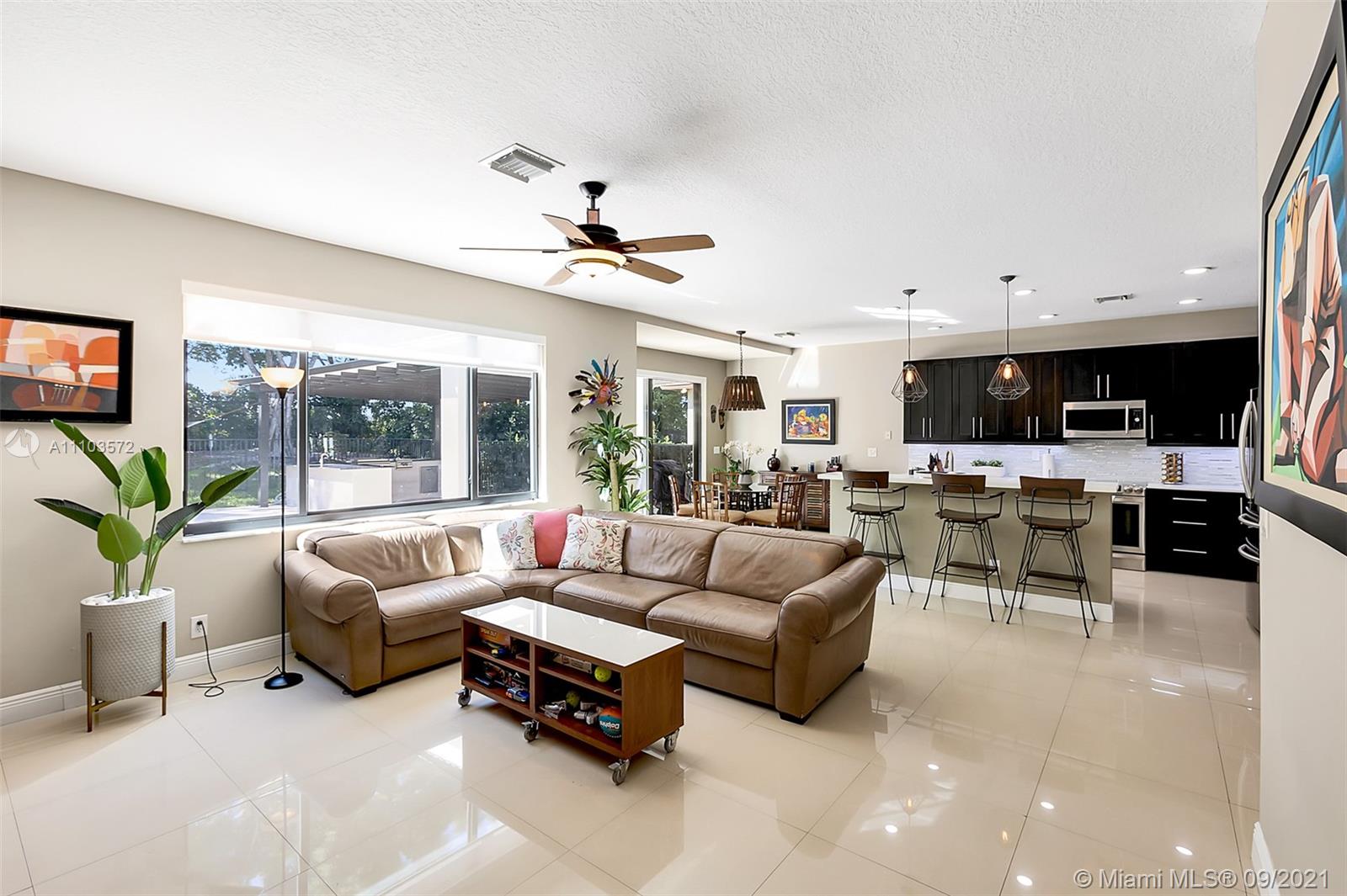 19124 Seneca Avenue Weston, FL 33332 - Photo 4 of 38 a living room with furniture kitchen view and a large window