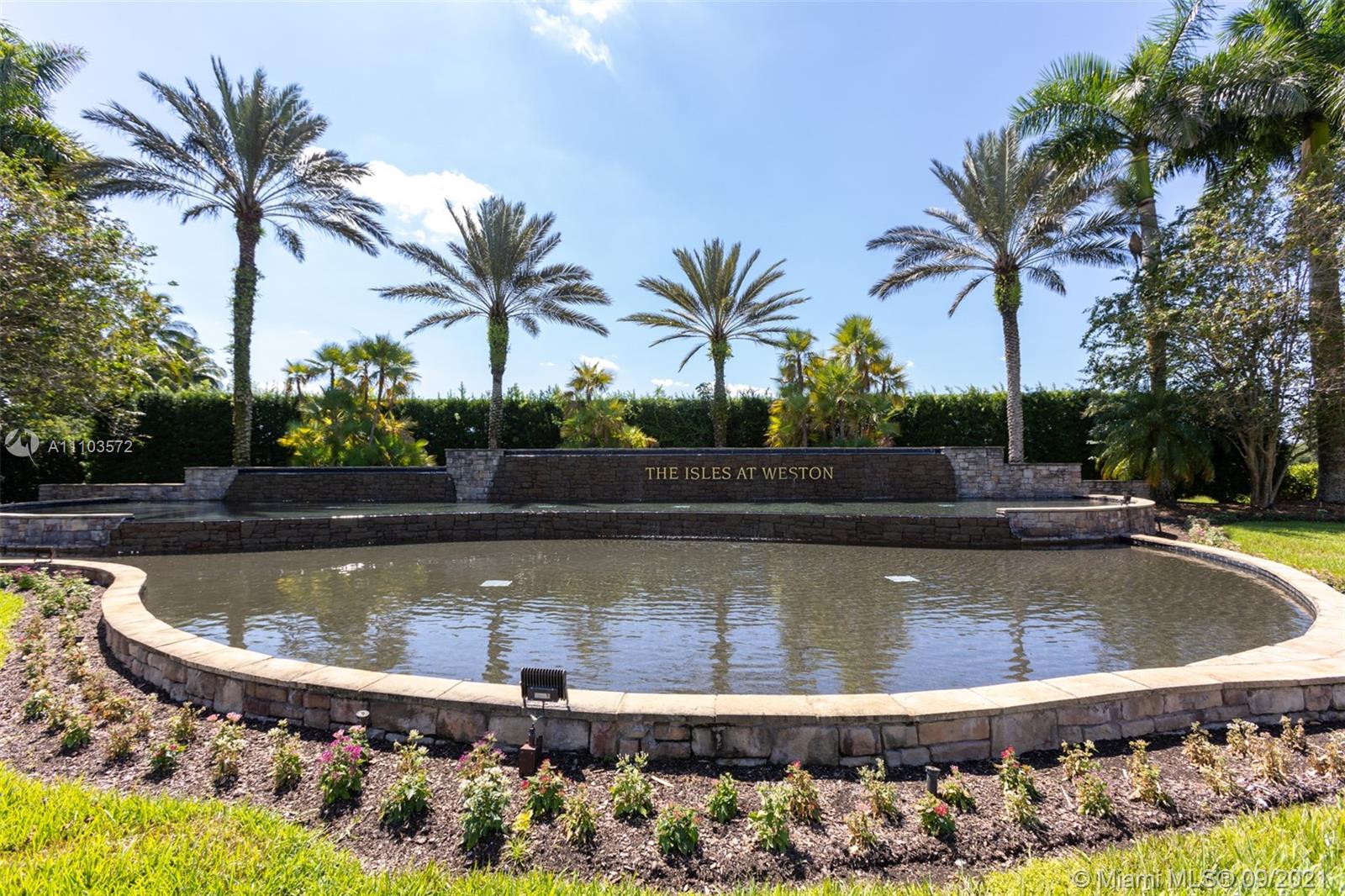 19124 Seneca Avenue Weston, FL 33332 - Photo 32 of 38 a view of a swimming pool with a table and chairs