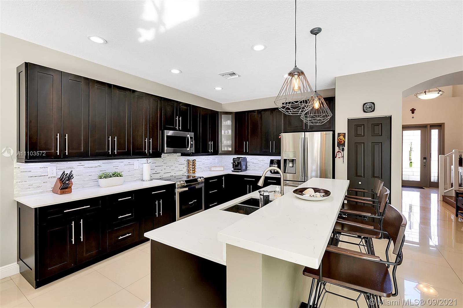 19124 Seneca Avenue Weston, FL 33332 - Photo 8 of 38 a large kitchen with a table and chairs