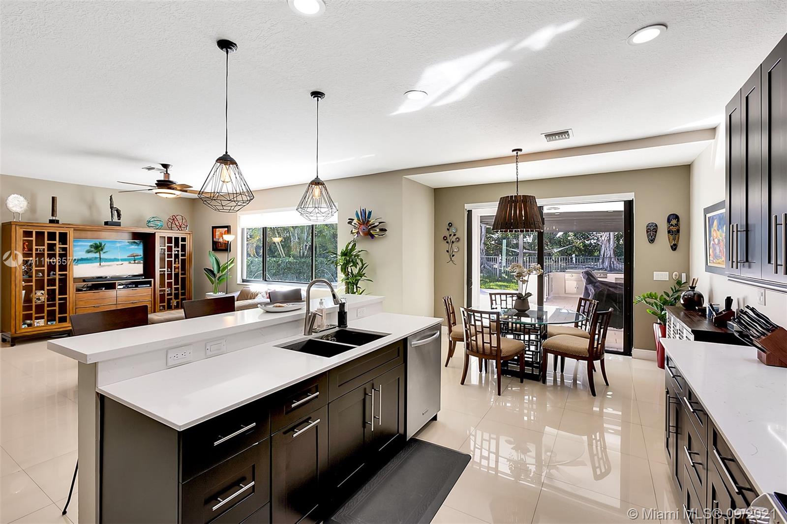19124 Seneca Avenue Weston, FL 33332 - Photo 9 of 38 a dining hall with stainless steel appliances granite countertop a stove and a view of living room