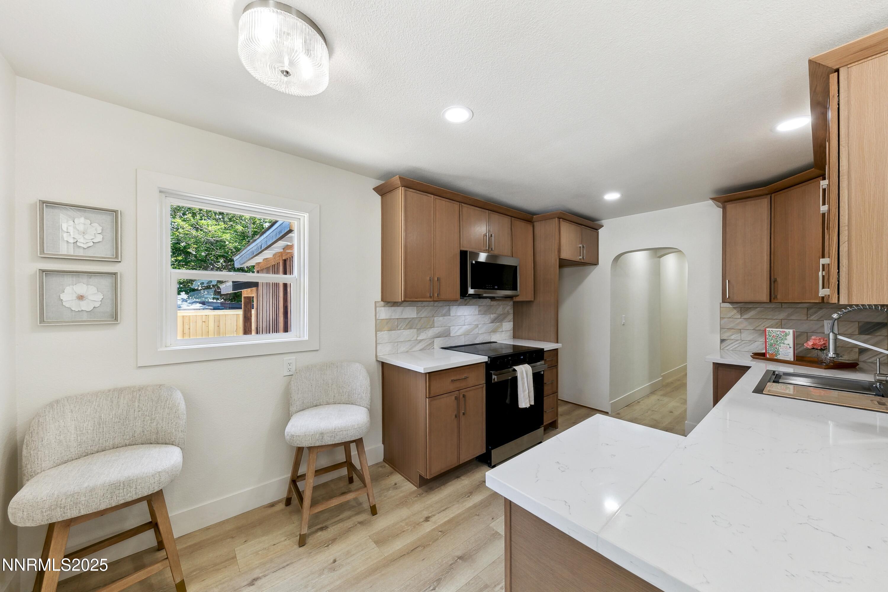 728 West Pueblo Street Reno, NV 89509 - Photo 12 of 33 a kitchen with a refrigerator a stove top oven a sink dishwasher and wooden cabinets with wooden floor