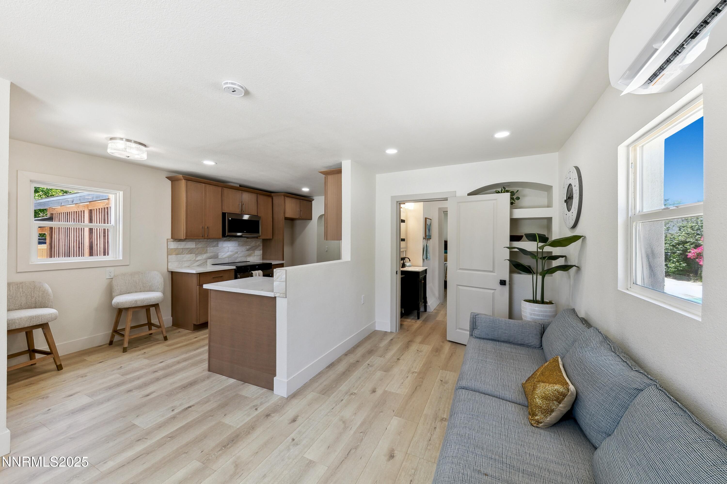 728 West Pueblo Street Reno, NV 89509 - Photo 10 of 33 a large white kitchen with stainless steel appliances kitchen island a stove a refrigerator a dining table and chairs with wooden floor