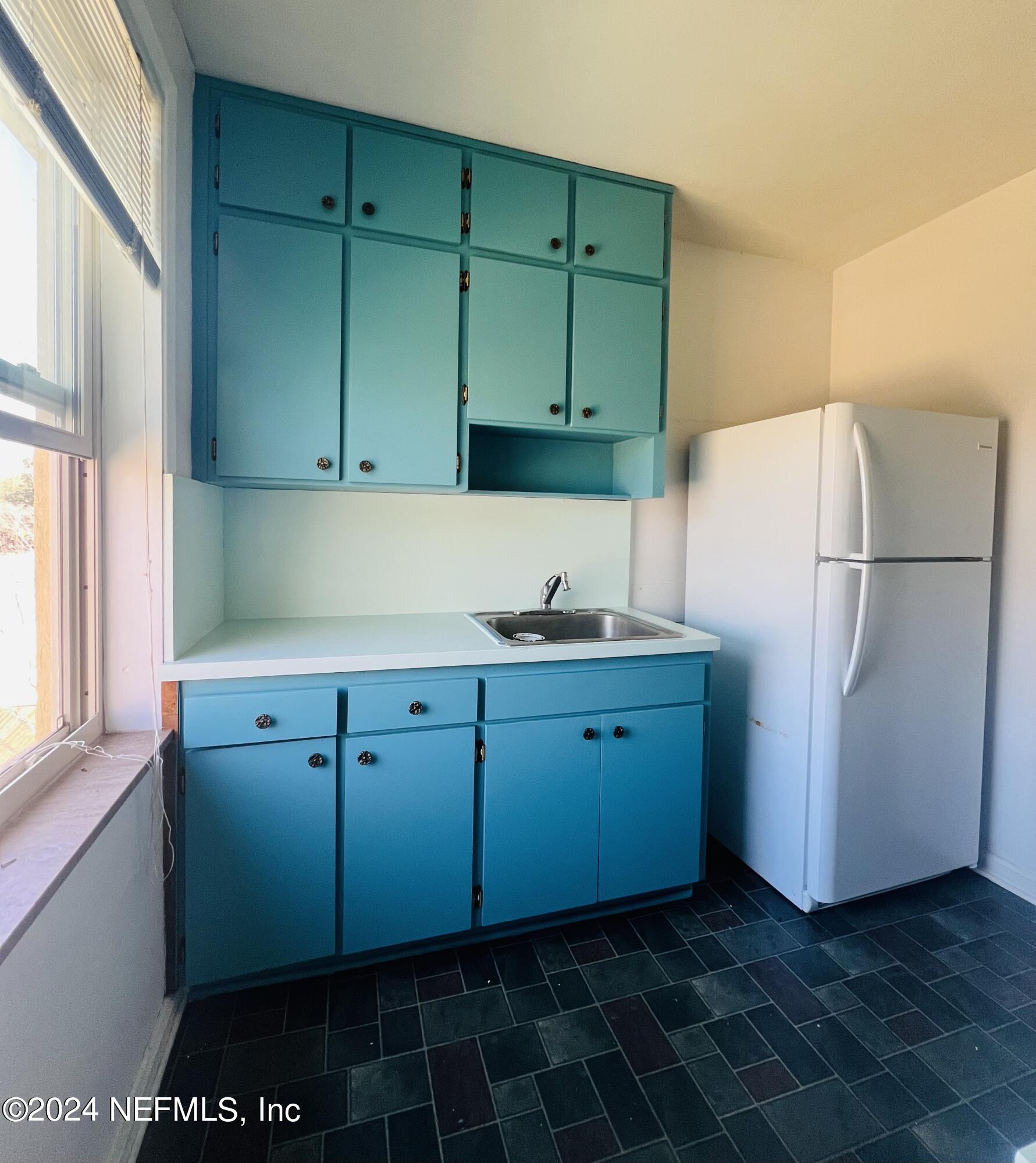1781 River Road, Unit 4 Jacksonville, FL 32207 - Photo 12 of 24 a kitchen with a refrigerator and a cabinets