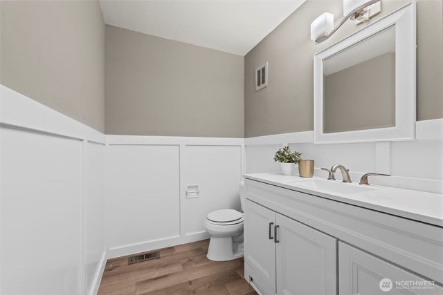 a bathroom with a granite countertop sink a toilet and a mirror