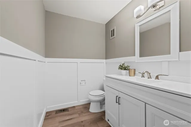 a bathroom with a granite countertop sink a toilet and a mirror