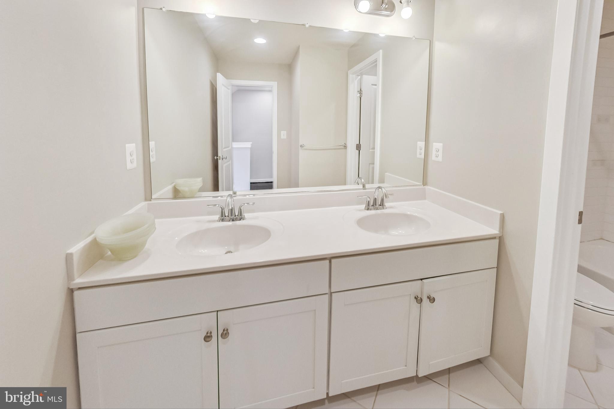 12609 Macaulay Street Silver Spring, MD 20906 - Photo 24 of 38 a bathroom with double sink and a mirror