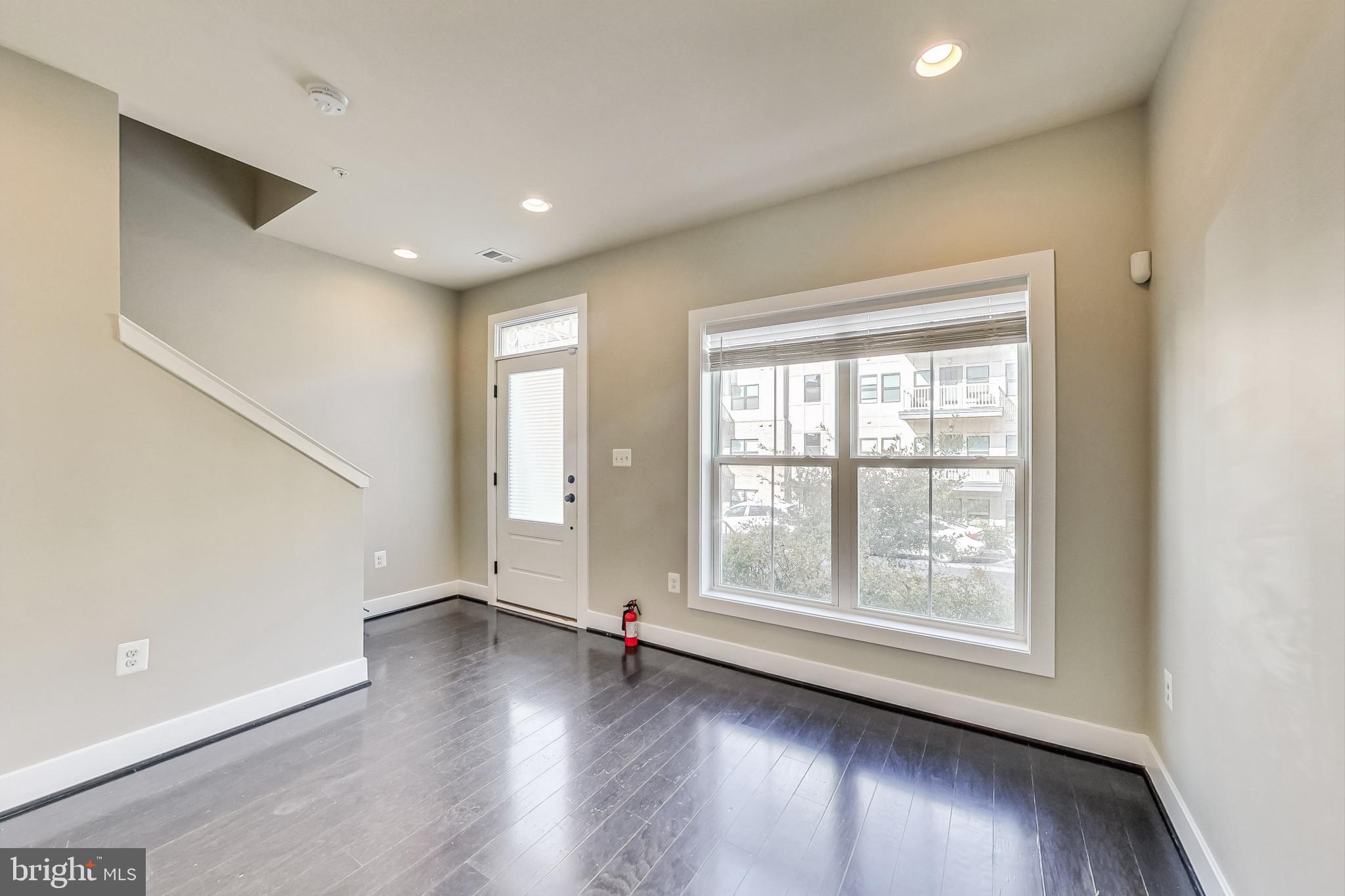 12609 Macaulay Street Silver Spring, MD 20906 - Photo 5 of 38 an empty room with wooden floor and windows