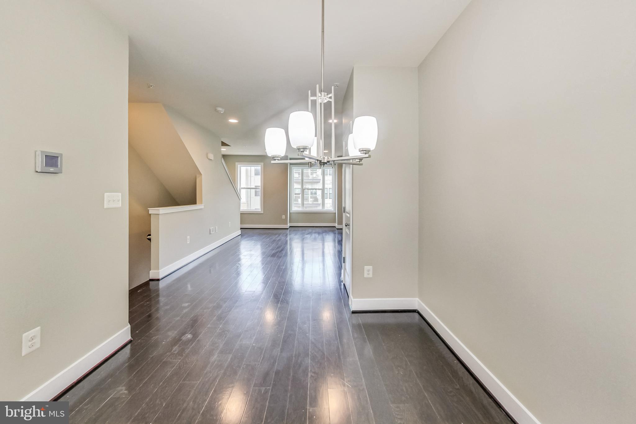 12609 Macaulay Street Silver Spring, MD 20906 - Photo 9 of 38 a view of a hallway with wooden floor and chandelier
