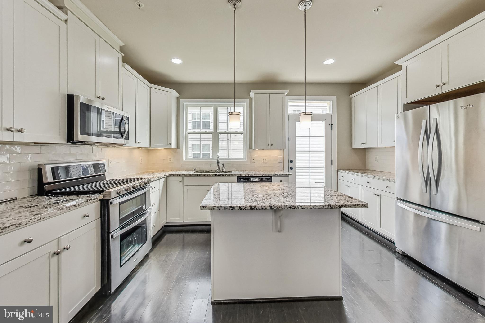 12609 Macaulay Street Silver Spring, MD 20906 - Photo 10 of 38 a kitchen with stainless steel appliances granite countertop a refrigerator a stove a sink and white cabinets