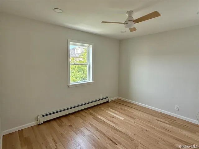 an empty room with a window and a ceiling fan