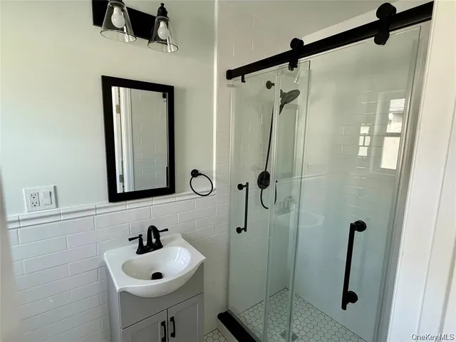 a bathroom with a sink a mirror and shower