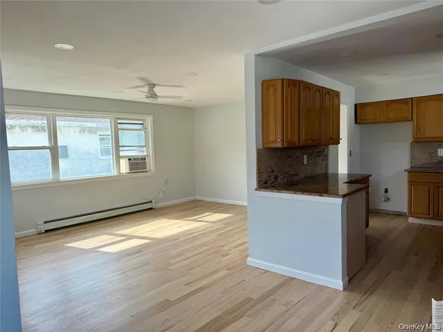 a kitchen with granite countertop white cabinets and wooden floor