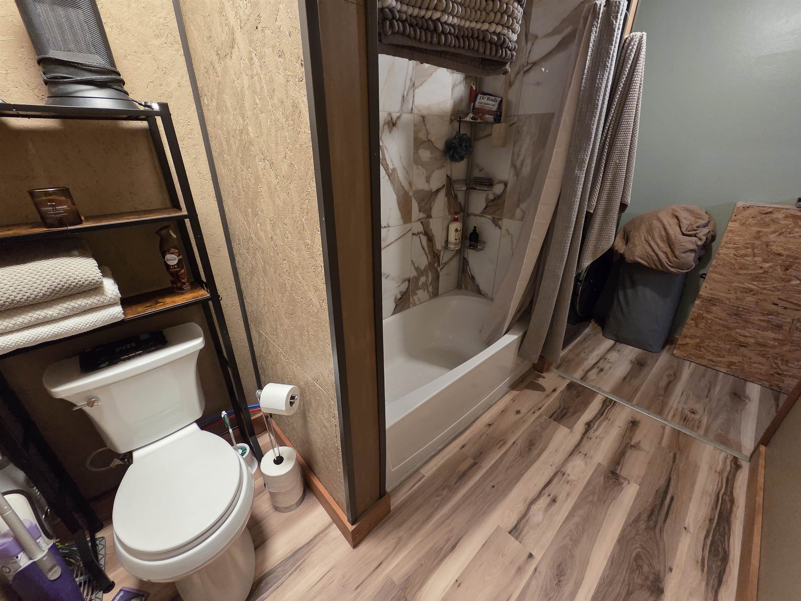 6821 Barrett Road Chisholm, MN 55719 - Photo 12 of 34 Bathroom with light wood-style floors, shower / bath combo, and a textured wall