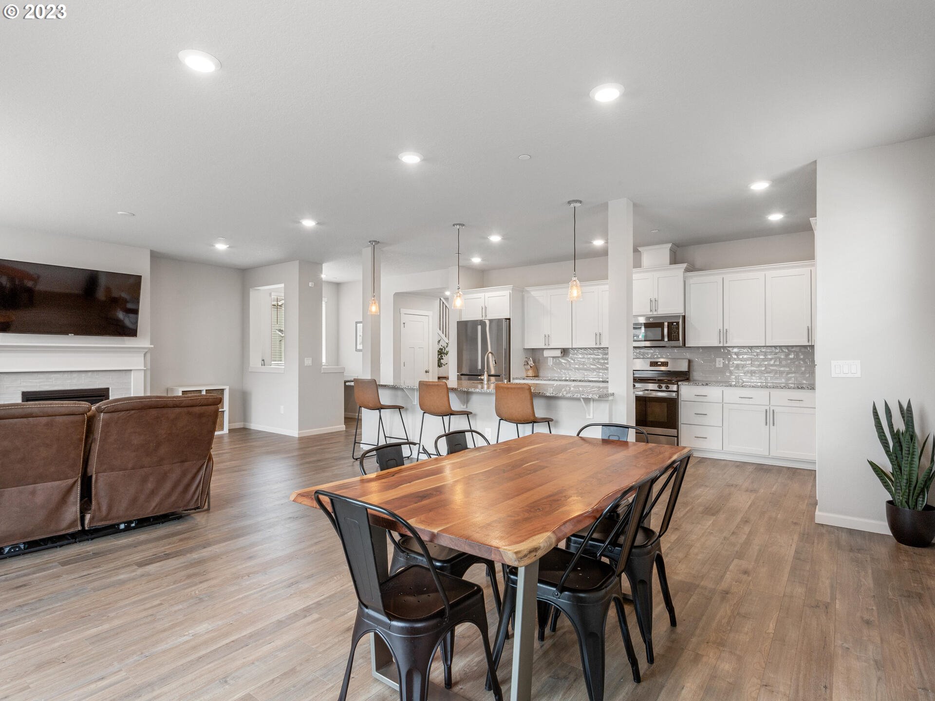 6852 North 89th Loop Camas, WA 98607 - Photo 12 of 38 a view of a dining room with furniture wooden floor and a kitchen