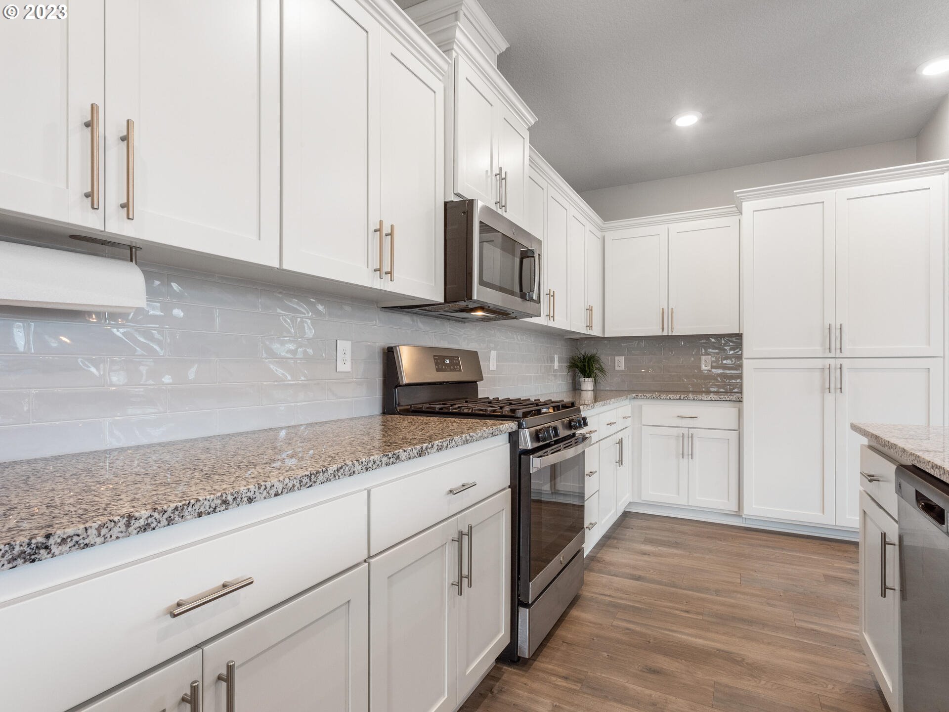 6852 North 89th Loop Camas, WA 98607 - Photo 10 of 38 a kitchen with granite countertop white cabinets and stainless steel appliances